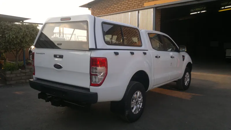 White Ford Ranger double cab fitted with a colour-matched canopy, rear three-quarter view.