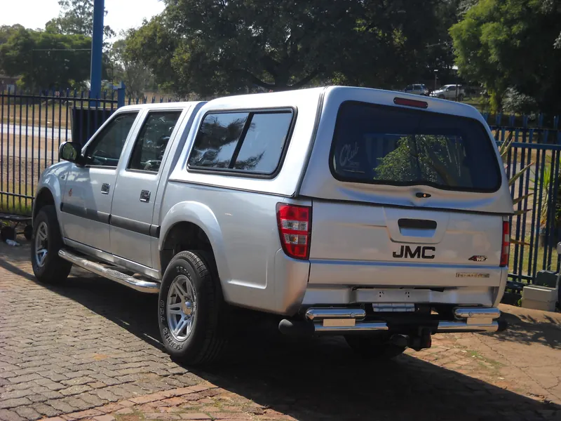 Silver JMC double cab with a colour-matched canopy.