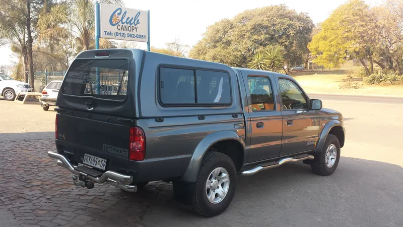 Grey Mazda double cab with a colour-matched canopy.