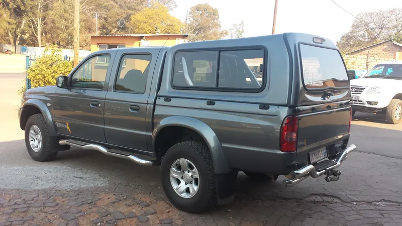 Grey Mazda double cab with a colour-matched canopy, side view.