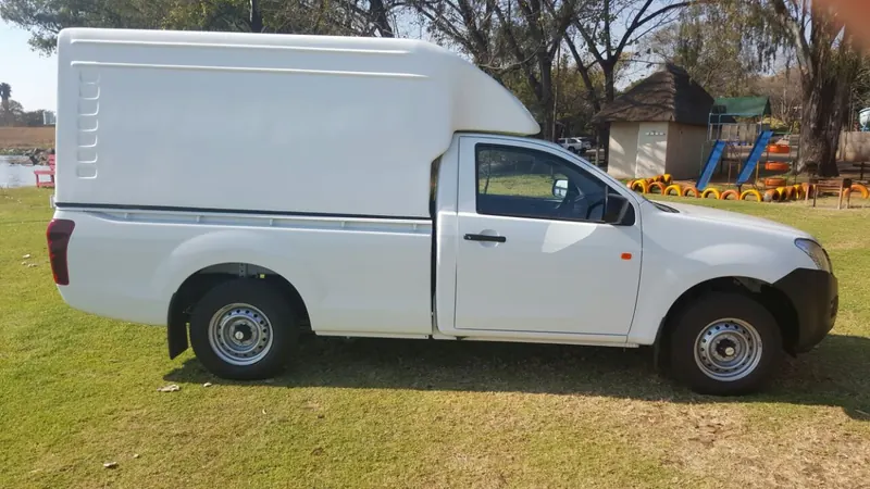 White Isuzu KB single cab with a Space Saver canopy, side view.