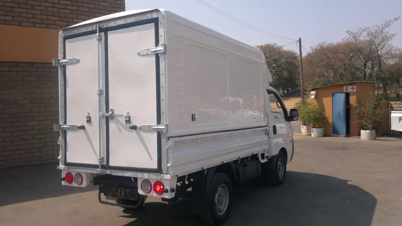 Kia K2700 with a tall Space Saver canopy and double rear doors.