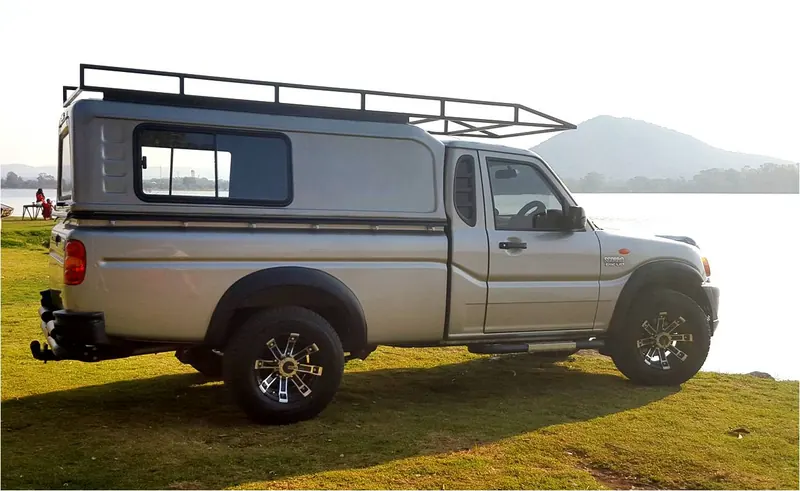 Silver Mahindra single cab with a colour-matched canopy and steel roof rack.