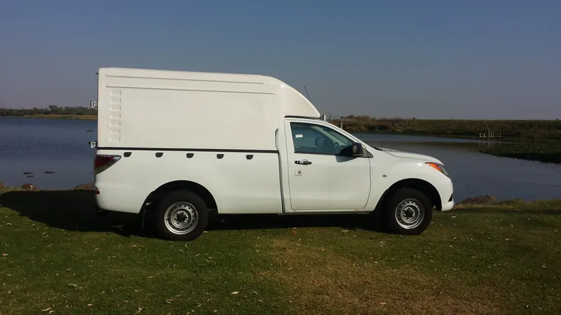 White Mazda BT-50 single cab with a Space Saver canopy, side view.