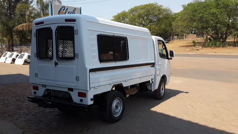 White Tata Super Ace with a canopy with mesh-protected windows and double rear doors.