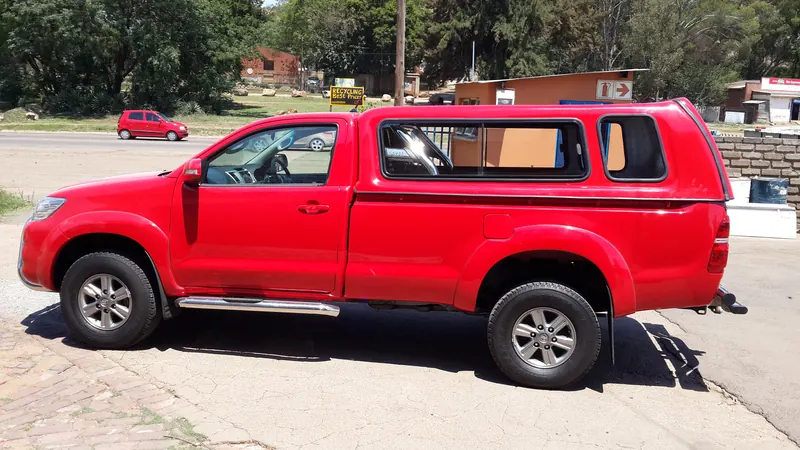 Red Toyota Hilux single cab with colour-matched canopy