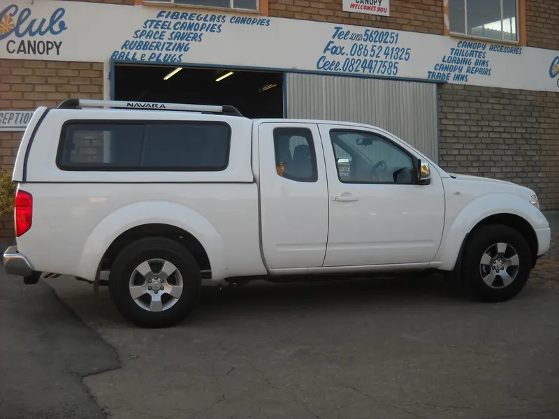 White Nissan Navara King Cab with canopy outside the Club Canopies workshop.