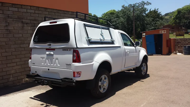White Tata Xenon single cab with canopy and roof rack, rear view.