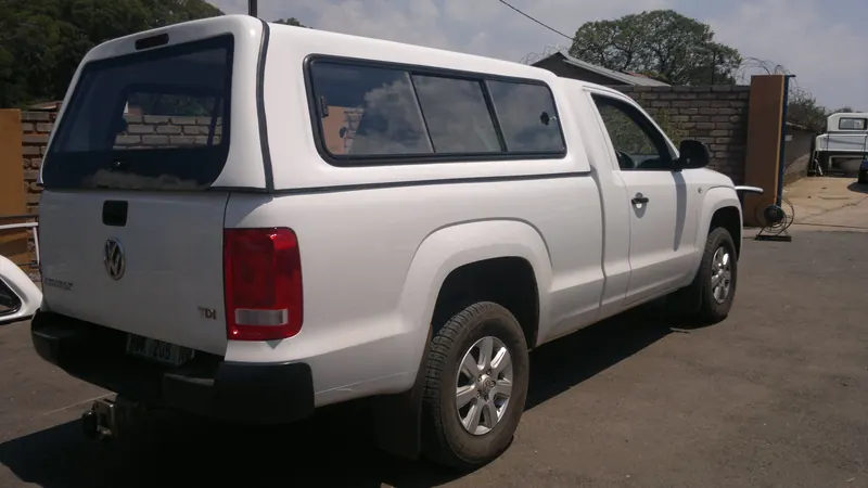 White Volkswagen Amarok single cab with a colour-matched canopy, rear view.