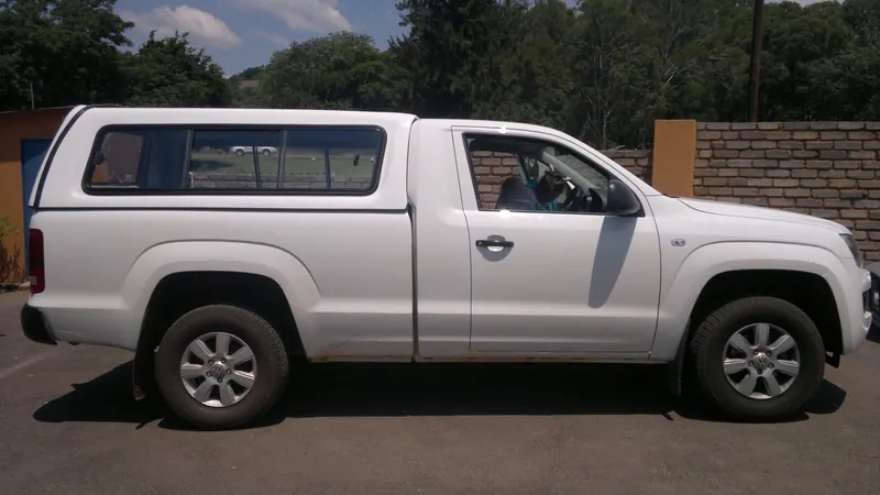 White Volkswagen Amarok single cab with a colour-matched canopy, side view.